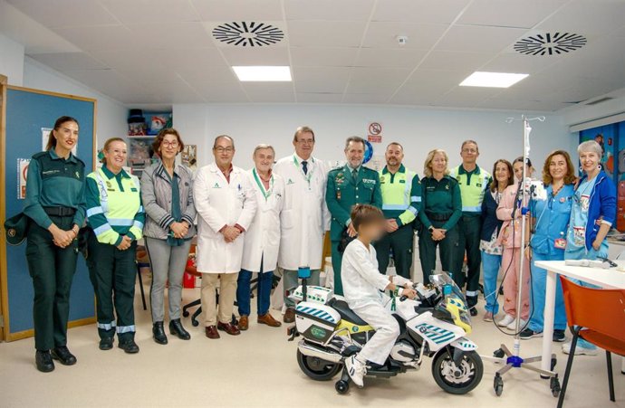 Un niño juega con la moto donada por la Guardia Civil.