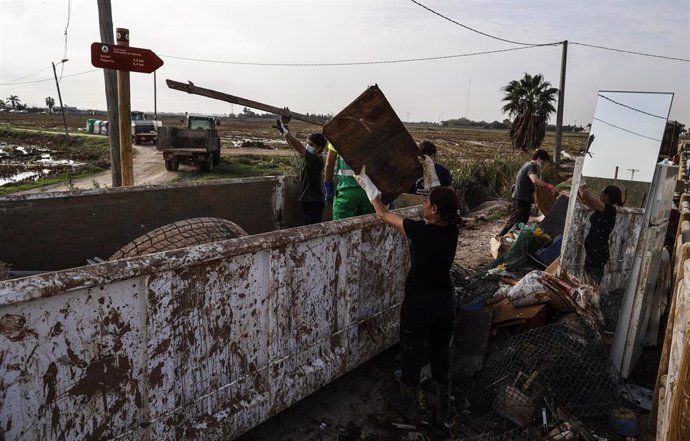 Varias personas ayudan a limpiar los estragos ocasionados por la DANA en una huerta, a 5 de noviembre de 2024, en Valencia