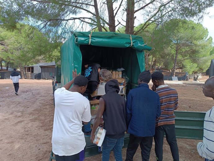 La Asociación La Carpa reparte alimentos y ropa en uno de los asentamientos de la provincia de Huelva.