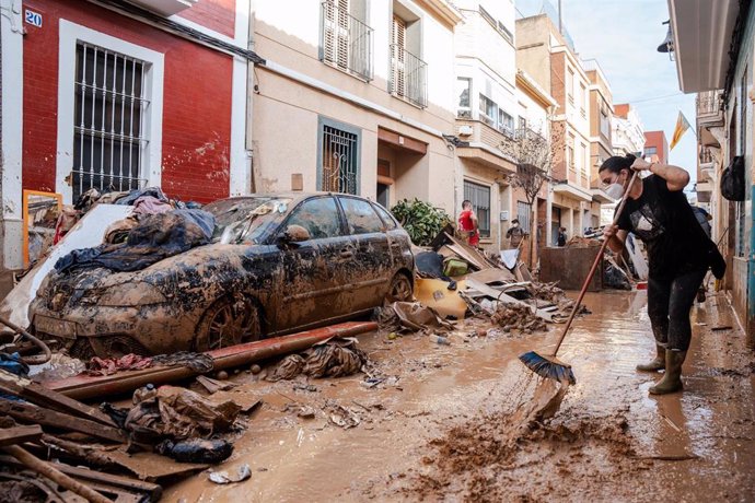 Una persona trata de limpiar el lodo en Catarroja, Valencia.