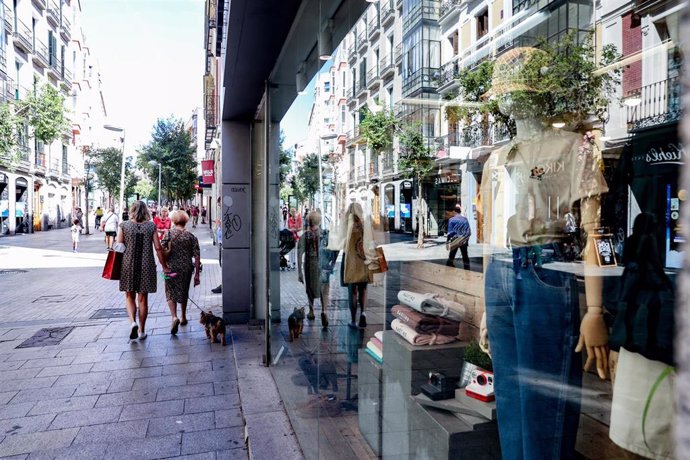 Archivo - Varias personas pasan por delante de un escaparate de una tienda de ropa. 