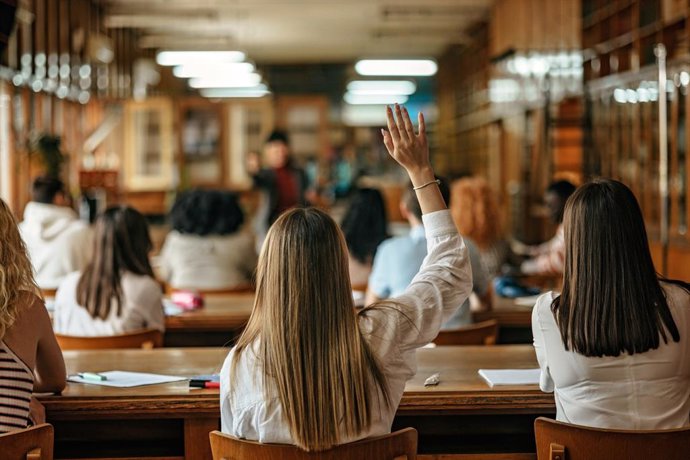 Archivo - Estudiante levantando la mano para hacer una pregunta en clase. Estudiar.