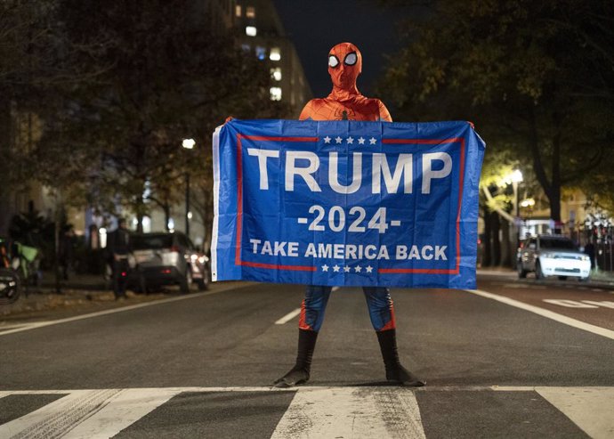 05 November 2024, US, Washington: A Trump supporter wearing a Spider-Man costume, stands with a banner supporting Trump on a road near the White House, on the US Election Night. Photo: Probal Rashid/ZUMA Press Wire/dpa