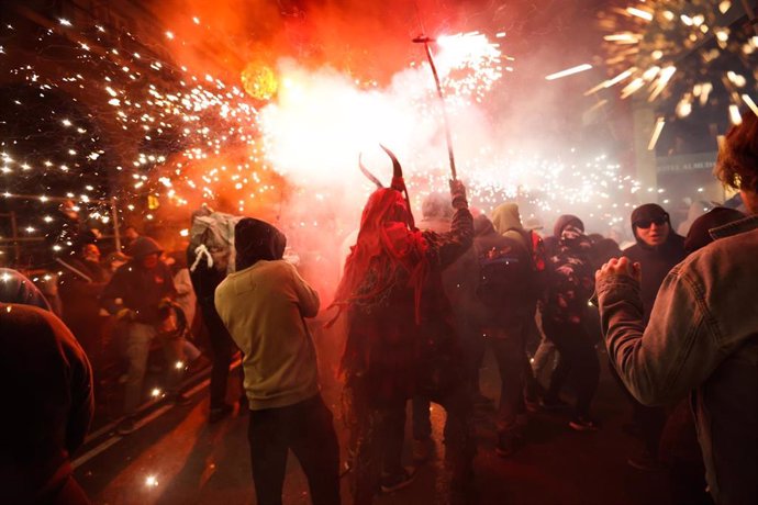 Archivo - Varias personas durante un correfoc en Palma que pone fin a las fiestas de San Sebastián.