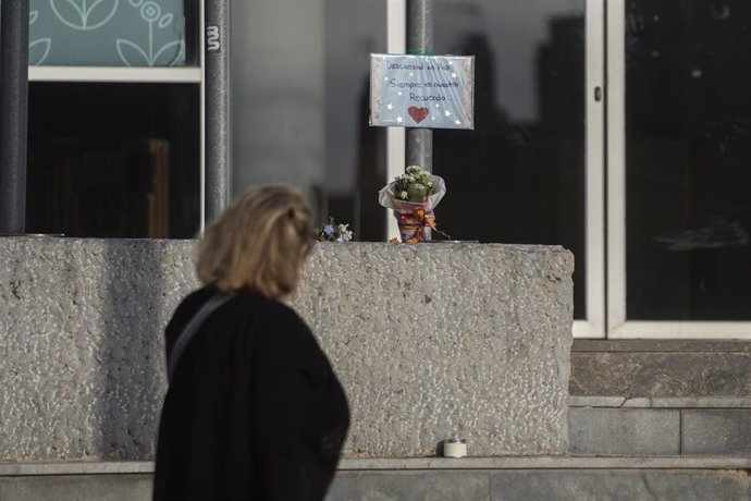 Una mujer observa un cartel y un ramo de flores en honor a los fallecidos por la Dana, en el exterior de la Feria de Valencia