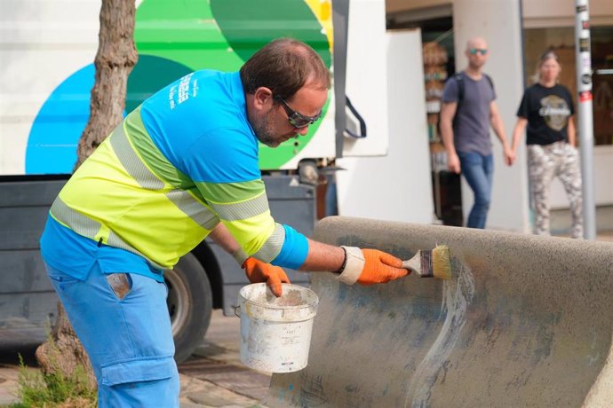 Un operario de Emaya trata de borrar un grafiti en un banco de Playa de Palma.