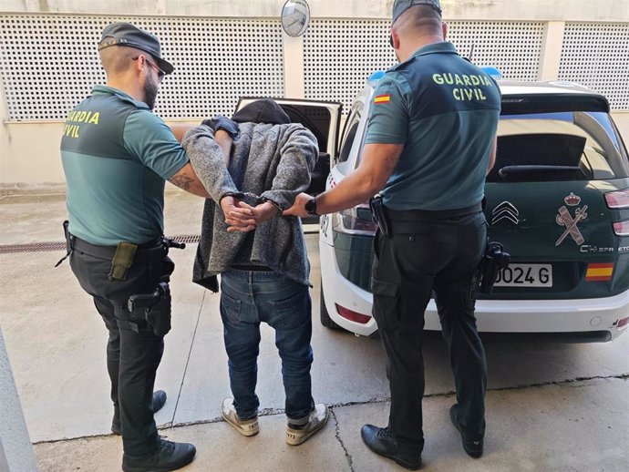 El detenido, conducido por dos agentes.