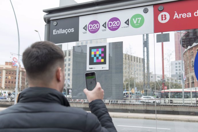 Archivo - Usuari escanejant el lector de codis DdTag en una estació de bus