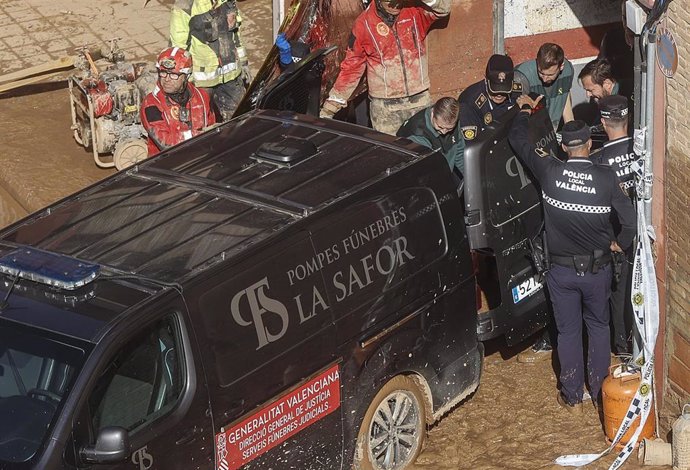 Un furgón de la funeraria sale de un garaje con cadáveres localizados tras el paso de la DANA, en el barrio de la Torre, a 31 de octubre de 2024, en Valencia