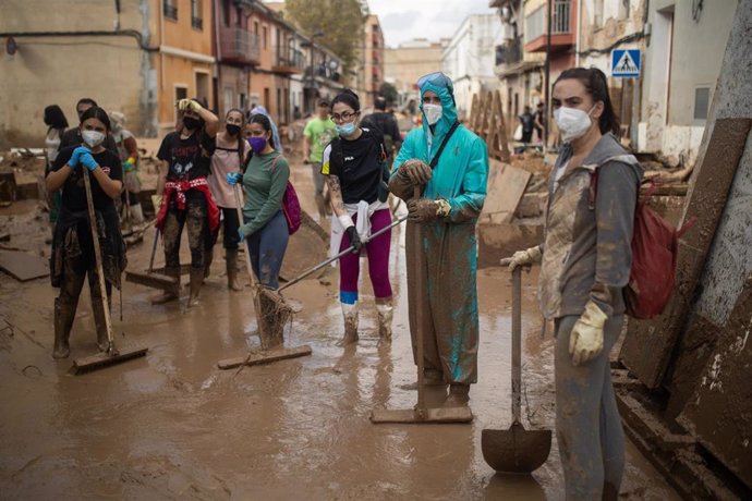 Varios voluntarios retiran barro de las calles con palas y cepillos, en el barrio de El Raval, a 6 de noviembre de 2024, en Algemesí, Valencia, Comunidad Valenciana (España).