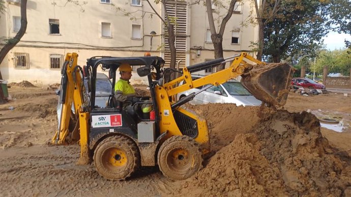 Un efectivo del dispositivo desplegado por el Ayuntamiento de Murcia maneja una retroexcavadora en una de las calles afectadas por la DANA