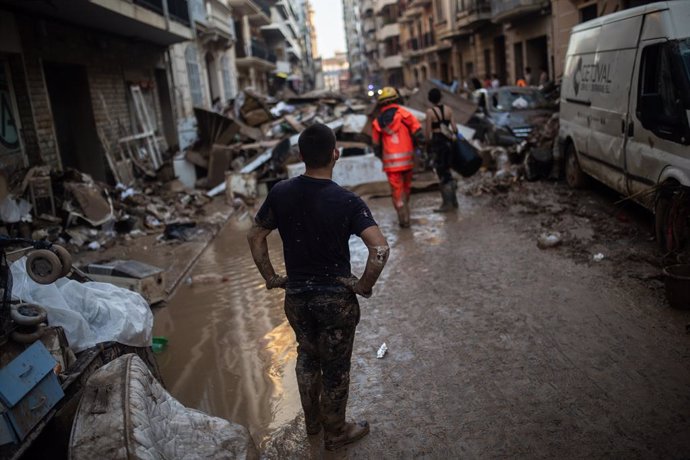 Varias personas limpian los estragos ocasionados por la DANA, a 6 de noviembre de 2024, en Algemesí, Valencia, Comunidad Valenciana (España). Una de las zonas más afectadas de Algemesí por la DANA es el barrio del Raval, donde el fango se acumula en monta