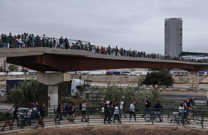 Imatge de voluntaris per a ajudar als afectats per la DANA en diferents localitats valencianes al seu pas pel pont que unix València amb la pednía de la Torre.