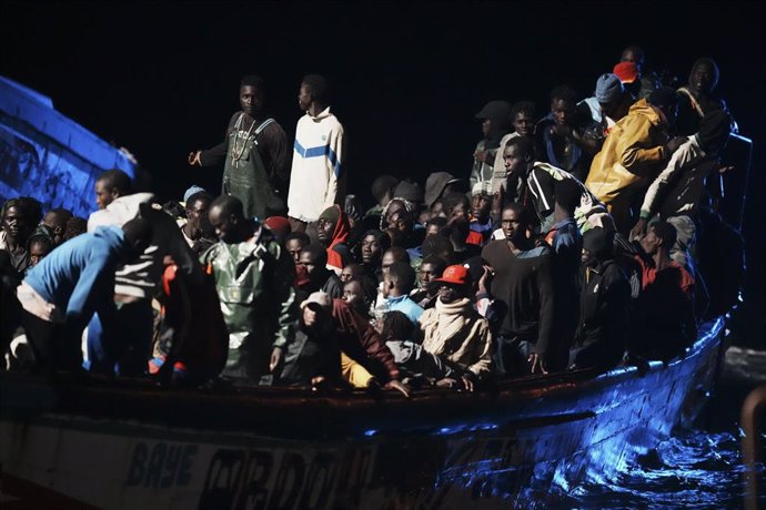 Archivo - Decenas de personas en un cayuco a su llegada al muelle de La Restinga