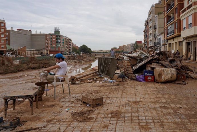 Una persona descansa en Paiporta, a 8 de noviembre de 2024, en Valencia, Comunidad Valenciana (España). Diez días después de la tragedia, los servicios de emergencia apuran hasta el límite la búsqueda de desaparecidos por la DANA en Valencia. El número de