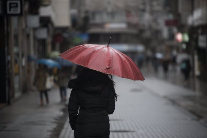 Archivo - Una persona con paraguas para protegerse de la lluvia camina por la Rua Michelena, a 16 de enero de 2023, en Pontevedra, Galicia (España). 