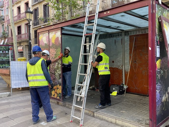 Operarios desmontan una parada.