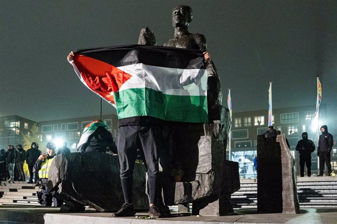 Un manifestante ondea una bandera palestina antes del comienzo del Ajax-Maccabi 