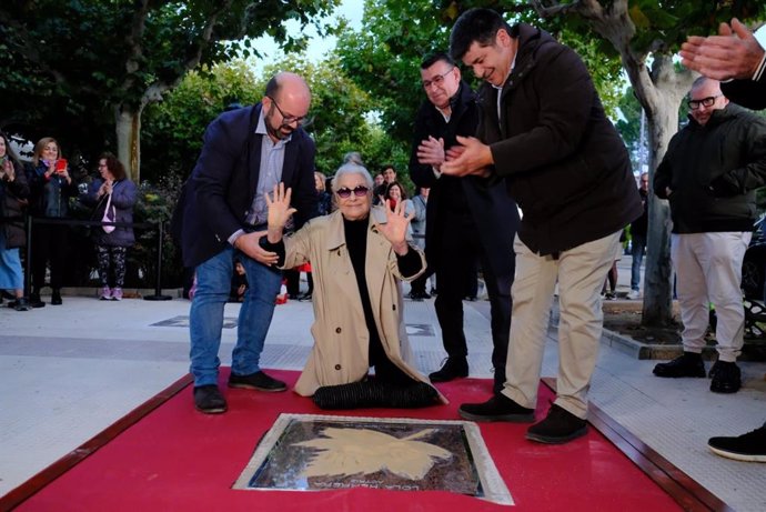 La actriz Lola Herrera saluda al público este domingo tras dejar sus huellas en el Paseo de las Estrellas de Cariñena. A su derecha, el alcalde  de la localidad zaragozana, Sergio Ortiz.