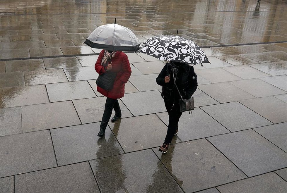 Archivo - Dos personas se refugian con un paraguas de la lluvia en Vitoria, País Vasco (España), a 19 de marzo de 2021. Para la jornada de hoy, está activado el aviso amarillo por debajo de los 1.000 metros y habrá precipitaciones débiles moderadas. Las