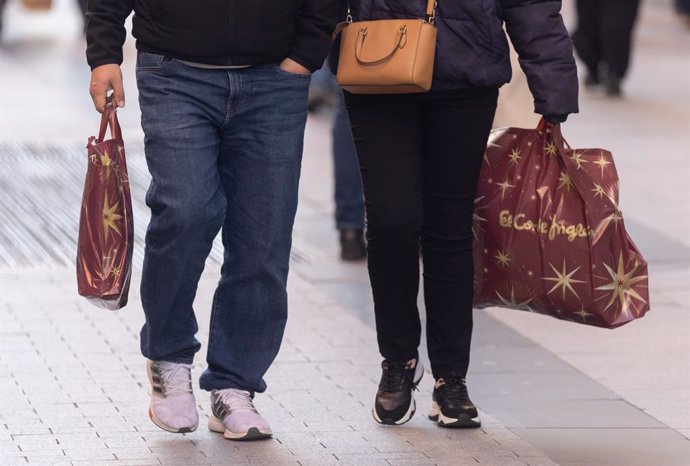 Archivo - Dos personas llevan bolsas con regalos para Reyes, a 5 de enero de 2024, en Madrid (España). Los españoles esperan gastar un 36% más en compras de Navidad este año que en 2022, con un gasto medio de 410 euros, según datos de Milanuncios. Del tot