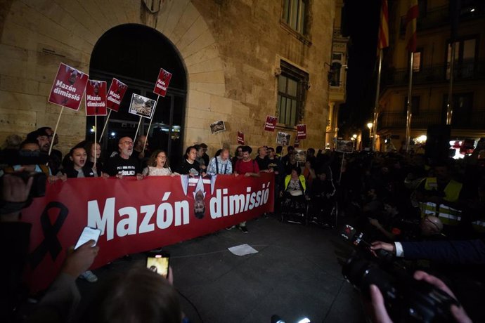 Varias personas con una pancarta durante una manifestación que recorre las calles de Valencia para exigir la dimisión del 'president' de la Generalitat