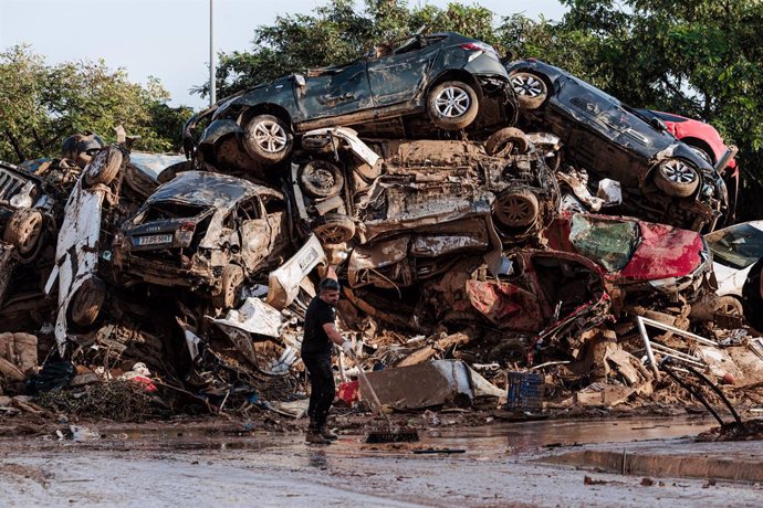 Varias personas limpian entre coches amontonados en Alfafar, a 5 de noviembre de 2024, en Valencia, Comunidad Valenciana (España). Hoy, se cumple una semana desde que la DANA arrasara la Comunitat Valenciana. Hasta el momento, hay 211 víctimas mortales y 