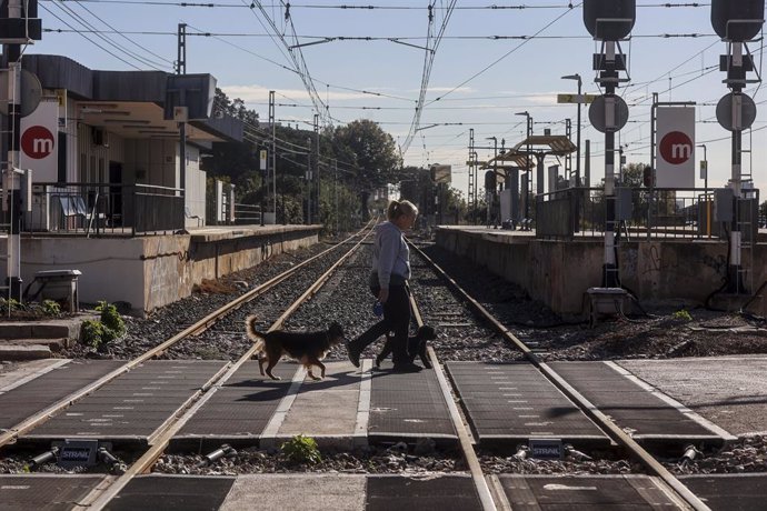 Un home passa per les vies del Metro al seu pas per Paterna en estar sense funcionament pel pas de la DANA,  a 11 de novembre del 2024, a Paterna, València