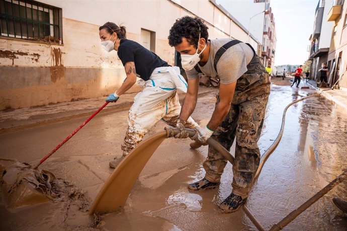 Imagen de dos personas realizando tareas de limpieza en una de las zonas afectadas por la DANA, en la localidad valenciana de Massanassa.   