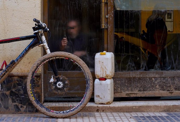 Un home neteja un cristall en el dia 13 després del pas de la DANA per Valencia