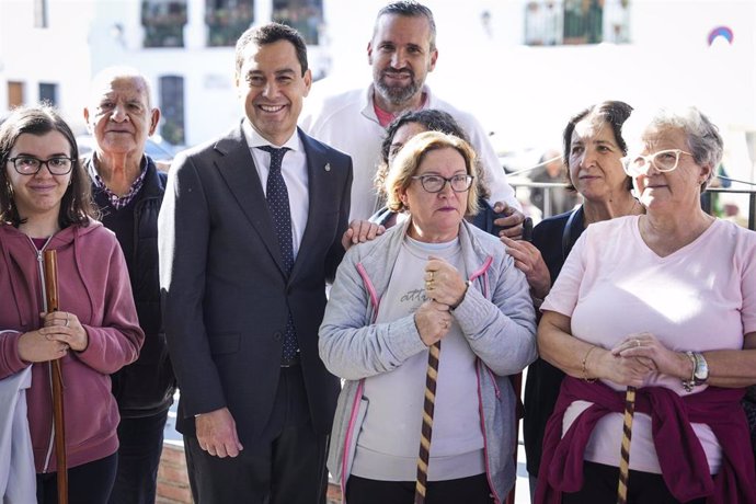 El presidente de la Junta de Andalucía, Juanma Moreno, junto a vecinos de Fuenteheridos (Huelva) durante su visita al municipio.