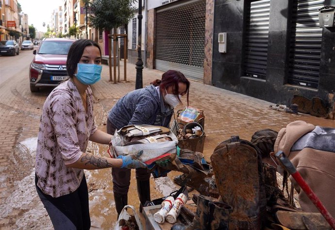 Varias personas con mascarillas recogen muebles tras el paso de la DANA en Aldaia, a 9 de noviembre de 2024, en Aldaia