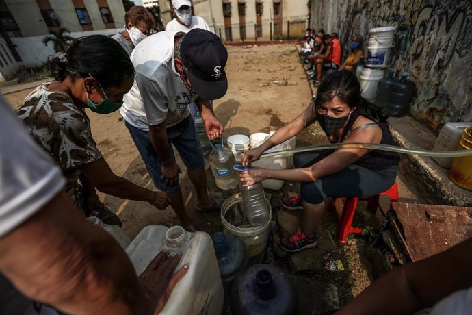 Archivo - FILED - 23 May 2020, Venezuela, Caracas: People queue up with canisters to get water amid the collapse of the country's water system, which has left many houses without running water. Photo: Pedro Rances Mattey/dpa