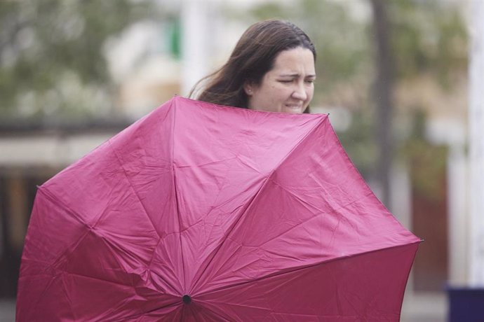 Archivo - Una chica aguanta su paraguas durante la llegada de la borrasca. Imagen de archivo. 