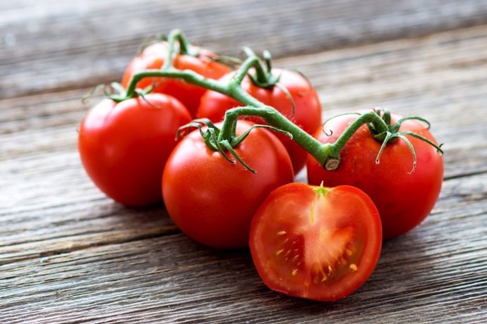 Archivo - Fresh tomatoes on wood background