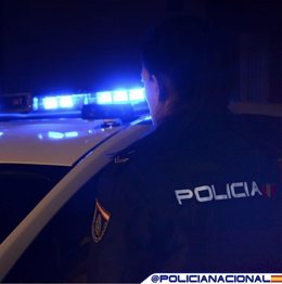 Archivo - Un agente de Policía Nacional junto a su vehículo