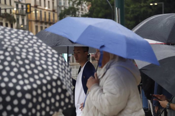 Personas con paraguas por las calles de Málaga.