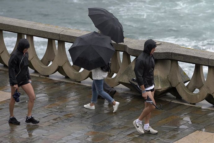 Archivo - Varias personas con paraguas caminan por el Paseo Marítimo de La Coruña, a 19 de junio de 2022, en A Coruña, Galicia, (España). 