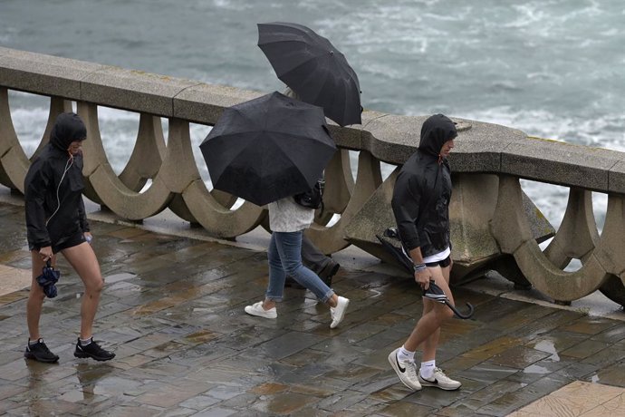 Archivo - Varias personas con paraguas caminan por el Paseo Marítimo de La Coruña, a 19 de junio de 2022, en A Coruña, Galicia, (España). La inestabilidad se mantendrá en Galicia al menos hasta la mitad de la semana que viene. A partir de mañana lunes 20 