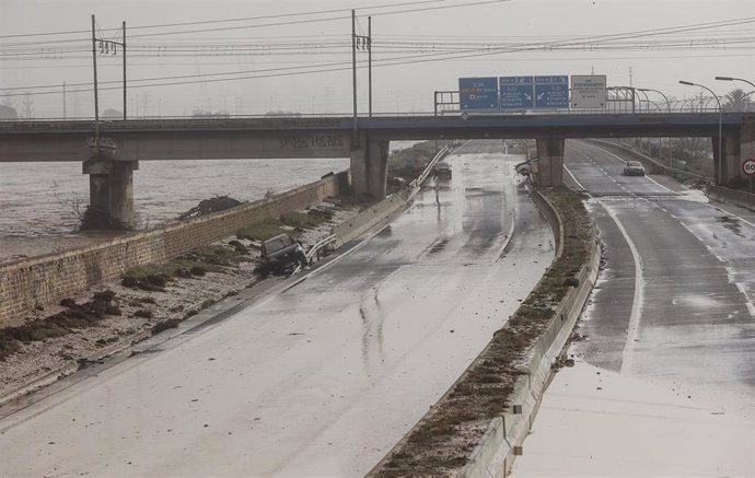 Varias personas recorren calles llenas de agua tras el paso de la DANA por el barrio de La Torre de Valencia