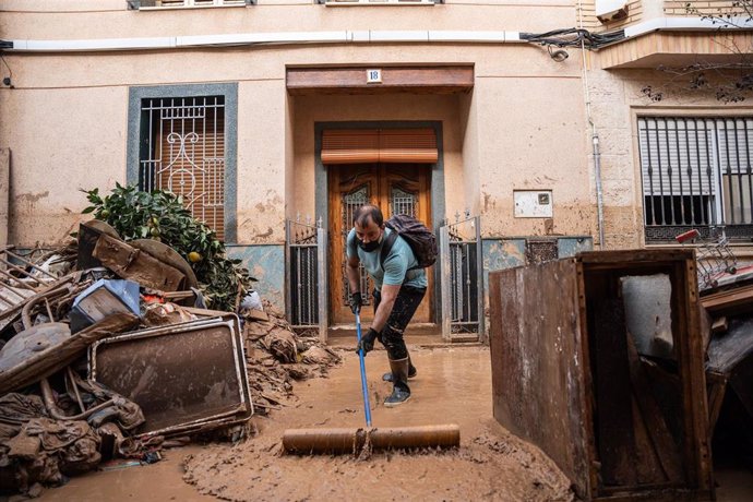 Una persona trata de limpiar el lodo, a 5 de noviembre de 2024, en Catarroja, Valencia