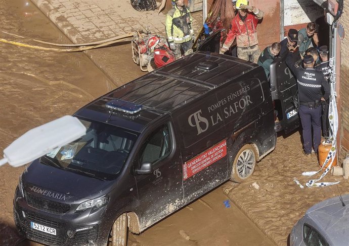 Un furgón de la funeraria sale de un garaje con cadáveres localizados tras el paso de la DANA, en el barrio de la Torre, a 31 de octubre de 2024, en Valencia