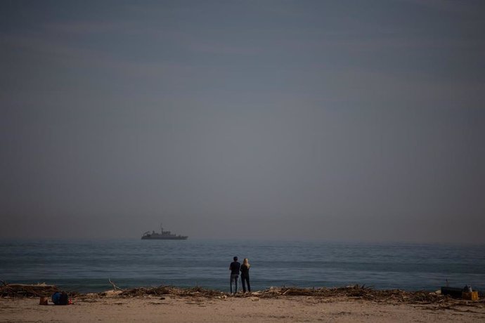 Dos personas en la playa de El Saler tras el paso de la DANA