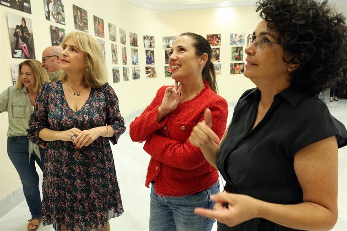 La secretaria de la Mesa del Parlamento de Canarias, Patricia Hernández (c), y la artista Mónica Rodríguez en la inauguración de la exposición fotográfica 'Mujeres en Mayúsculas'