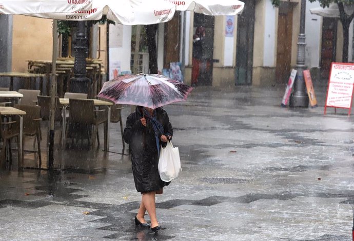 Una mujer camina con un paraguas para protegerse de la lluvia en Jerez de la Frontera.