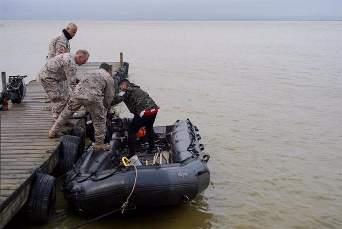 Varios militares de la Armada preparan una lancha para el trabajo de búsqueda en L'Albufera de València.