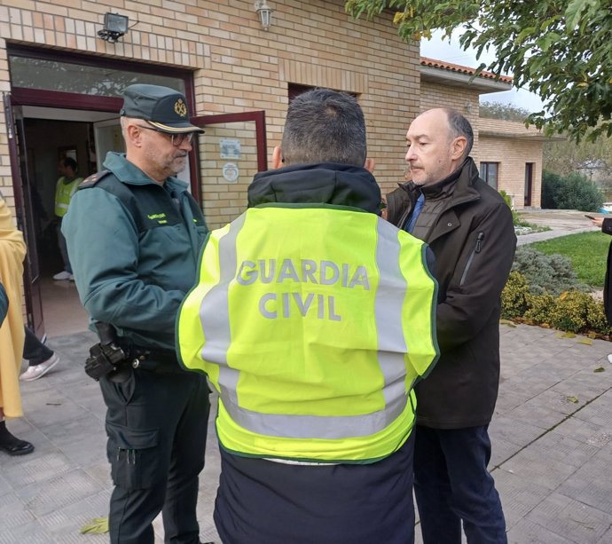 El delegado del Gobierno en Aragón, Fernando Beltrán, con agentes de la Guardia Civil cerca de la residencia de Villafranca de Ebro incendiada, en la que han perdido la vida diez personas.