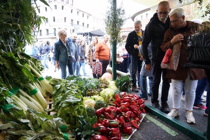 Archivo - Varias personas observan un puesto de verduras en la feria del agro vasco del ‘Último Lunes de Octubre’