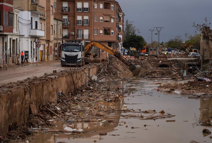 Una grua arreplega i neteja els enderrocs i els cotxes danyats per la DANA, a 13 de novembre del 2024, a Catarroja