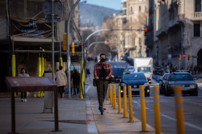 Archivo - Un hombre en patinete por Via Laietana, antes de ser peatonal, a 17 de febrero de 2022, en Barcelona, Catalunya (España).